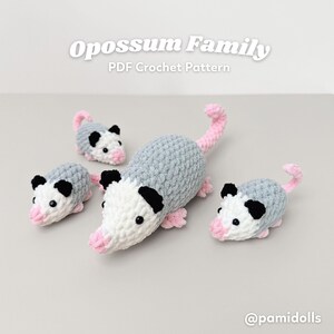 K&ouml;nnte beinhalten: Eine Familie geh&auml;kelter Opossums in verschiedenen Gr&ouml;&szlig;en. Die Opossums sind grau, wei&szlig;, schwarz und rosa. Der Text "Opossum Family PDF Crochet Pattern" befindet sich oben im Bild, und der Instagram-Handle "@pamidolls" befindet sich unten.