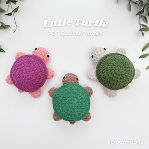 Puede incluir: Tres tortugas de ganchillo hechas a mano en rosa, verde y blanco. Cada tortuga tiene un caparazón texturizado y pequeñas extremidades. El texto "Little Turtle PDF Crochet Pattern" se muestra encima de las tortugas.