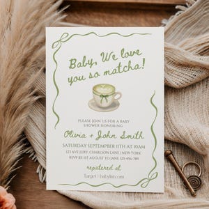以下が含まれることがあります： 「Baby, We love you so matcha!」と緑色の文字で書かれたベビーシャワーの招待状。招待状には、オリビアとジョン・スミスのベビーシャワーの詳細（日付、時間、場所など）が含まれています。