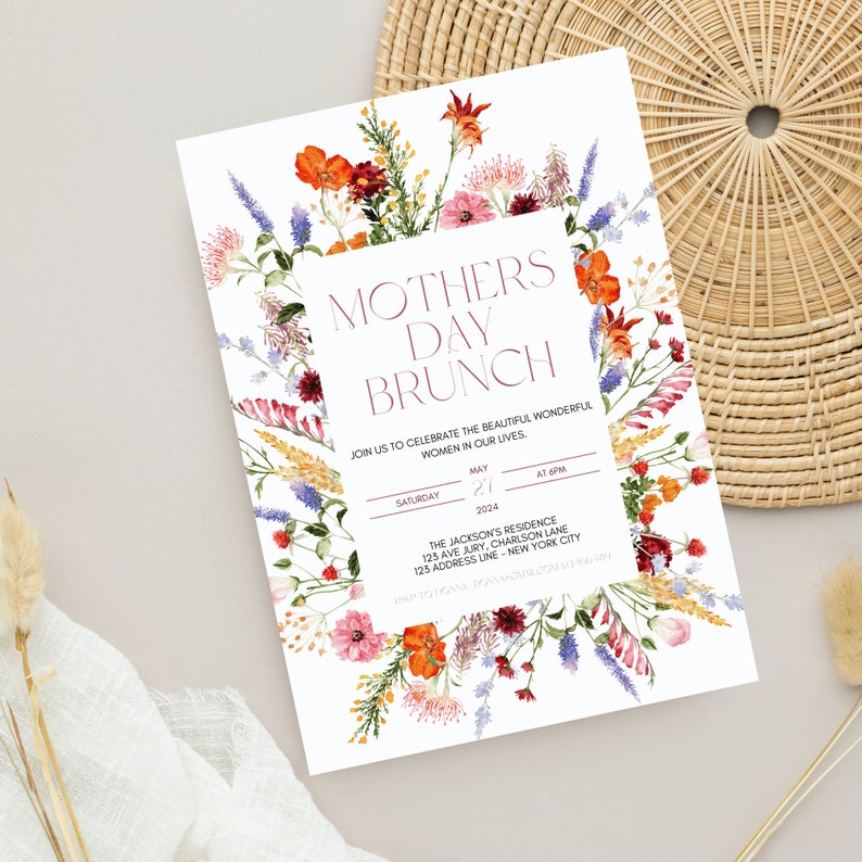 Pu&ograve; includere: Un invito bianco con il testo "Mothers Day Brunch" in bordeaux, circondato da un bordo floreale di fiori rossi, arancioni, rosa e viola. L'invito include i dettagli per un brunch il 21 maggio 2024, alle 18:00.