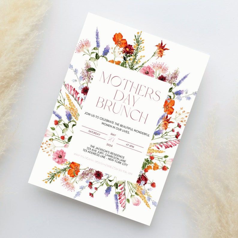 Pu&ograve; includere: Un invito per un brunch della festa della mamma con bordo floreale. L'invito presenta il testo "Mothers Day Brunch". L'invito include la data, l'ora e il luogo dell'evento. Il bordo floreale comprende fiori arancioni, rosa e viola.