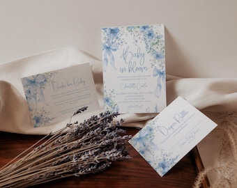 Op de afbeelding: Drie baby shower uitnodigingen met een blauw en wit aquarel bloemenontwerp. De uitnodigingen zeggen "Baby in Bloom" en "Diaper Raffle".