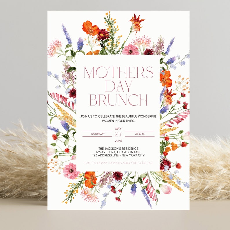 Pu&ograve; includere: Un invito per un brunch della festa della mamma con bordo floreale. L'invito presenta il testo "Mothers Day Brunch" in un riquadro rettangolare, con i dettagli dell'evento sottostanti. Decorato con fiori e verde colorati.