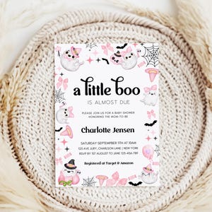 Puede incluir: Una invitaci&oacute;n de baby shower blanca con un tema de Halloween en rosa y negro. La invitaci&oacute;n presenta un fantasma con un lazo rosa y el texto "a little boo is almost due". La invitaci&oacute;n tambi&eacute;n incluye el texto "Charlotte Jensen" y los detalles para la baby shower.