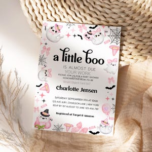 Puede incluir: Una invitaci&oacute;n a una fiesta de bienvenida al beb&eacute; de color rosa y negro con un fantasma que lleva un sombrero de bruja y el texto "a little boo is almost due your work". La invitaci&oacute;n tambi&eacute;n incluye el texto "Saturday September 11th at 10am 125 Ave Jury, Charleston Lane | New York RSVP by 1st August to Jane 123-456-789 Registered at Target & Amazon".