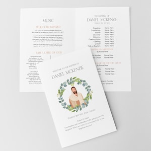 Könnte beinhalten: Eine weiße Karte mit einer Aquarell-Illustration von Jesus in einem Kranz aus grünen Blättern. Der Text "Willkommen zur Taufe von Daniel McKenzie" steht oben auf der Karte. Datum und Uhrzeit der Taufe sind unten auf der Karte angegeben.