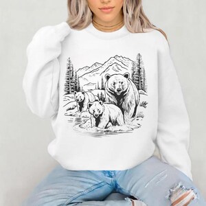 May include: White sweatshirt with a black and white illustration of three bears in a mountain landscape. The bears are standing in a stream of water.