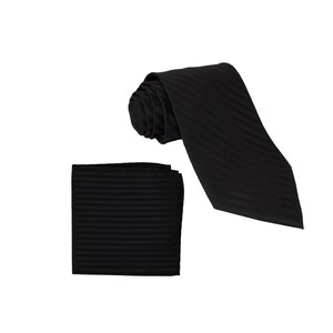 Könnte beinhalten: Ein schwarzes gestreiftes Krawatten- und Einstecktuch-Set. Die Krawatte ist aufgerollt und das Einstecktuch liegt flach.