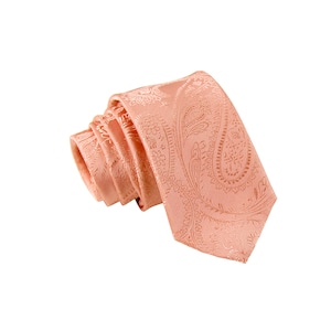 May include: A peach-colored paisley patterned tie. The tie is folded and tied in a knot.