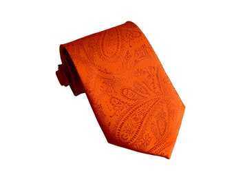 Può includere: Una cravatta arancione con motivo paisley. La cravatta è realizzata in materiale setoso e ha un design classico.