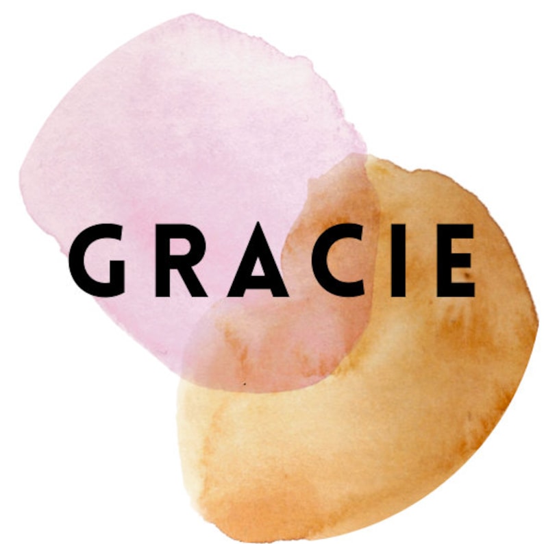 May include: Watercolor painting of the name "GRACIE" in black text on a pink and orange background.