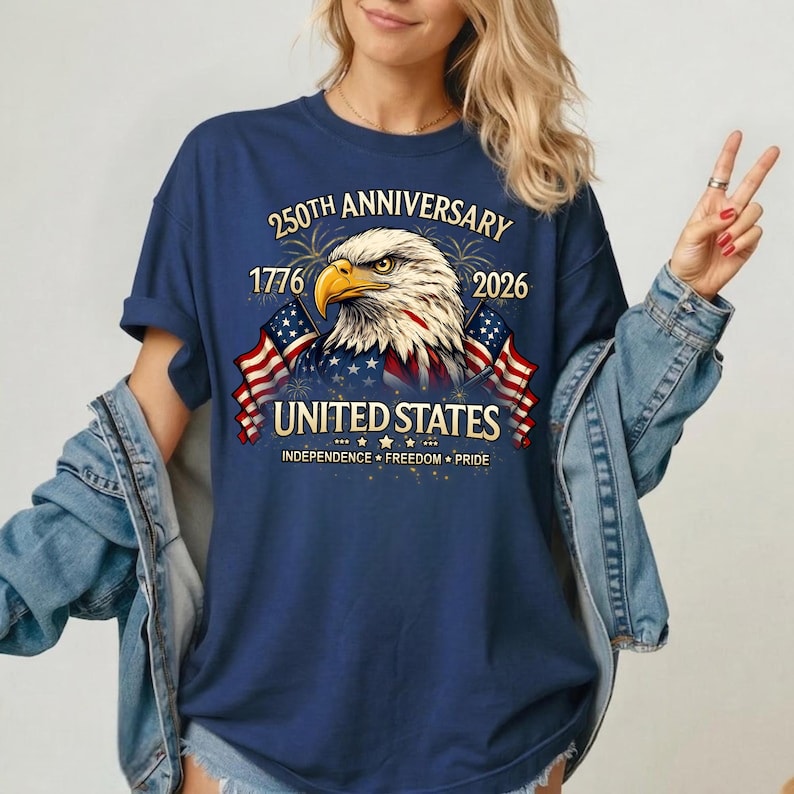 May include: Navy blue t-shirt featuring a detailed graphic of an American bald eagle with the text "250th Anniversary 1776-2026 United States Independence Freedom Pride". The design includes American flags and fireworks.