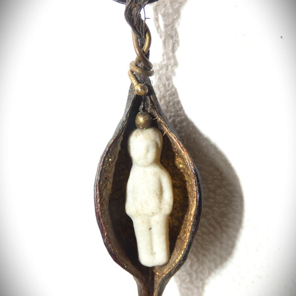 Small antique porcelain doll 2.5 cm, hidden in a seed capsule