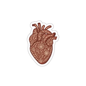 May include: A sticker featuring a stylized anatomical heart design. The heart is a deep reddish-brown color and is intricately decorated with floral and leaf patterns in a lighter beige hue. The sticker has a white border.