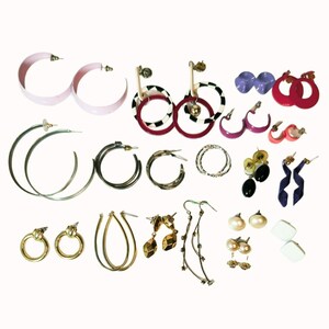 May include: A collection of various earrings in different styles and colors. Includes large hoop earrings in pink and silver, gold drop earrings, and pearl stud earrings. Other earrings feature geometric shapes and abstract designs.