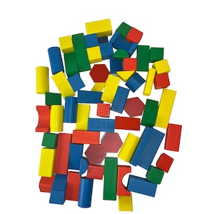 Könnte beinhalten: Eine Sammlung bunter Holzbausteine in verschiedenen Formen, darunter Quadrate, Rechtecke und Sechsecke. Die Blöcke sind kreisförmig angeordnet und aus leuchtend rotem, gelbem, blauem und grünem Holz gefertigt.