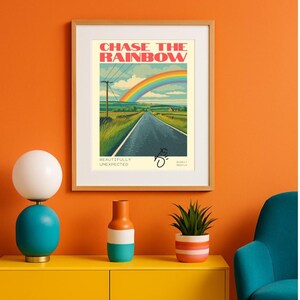 May include: Framed art print featuring the text "CHASE THE RAINBOW" above a rainbow over a road. The print also includes the text "BEAUTIFULLY UNEXPECTED" and a signature. The artwork is in a wooden frame.
