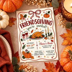 May include: A rectangular Friendsgiving invitation card featuring a central roasted turkey, wine glasses, pumpkins, and autumn leaves. The text reads: Friendsgiving you're invited, Saturday Nov 23rd at 6:30pm, at Olivia's House, 123 Maple Street, Nashville, TN.