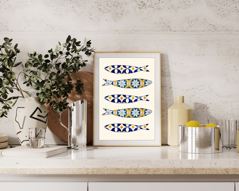 May include: A framed print of five blue, yellow, and white fish with geometric patterns. The fish are arranged vertically on a cream background.