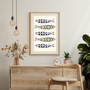 May include: A framed print of five blue and white fish with yellow accents, arranged vertically on a white background. The fish are stylized to resemble Portuguese sardines.
