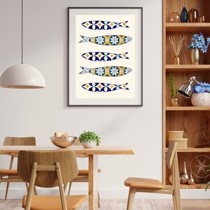 May include: A framed print of five blue and white fish with yellow accents, arranged vertically on a white background. The fish are stylized and resemble Portuguese sardines.