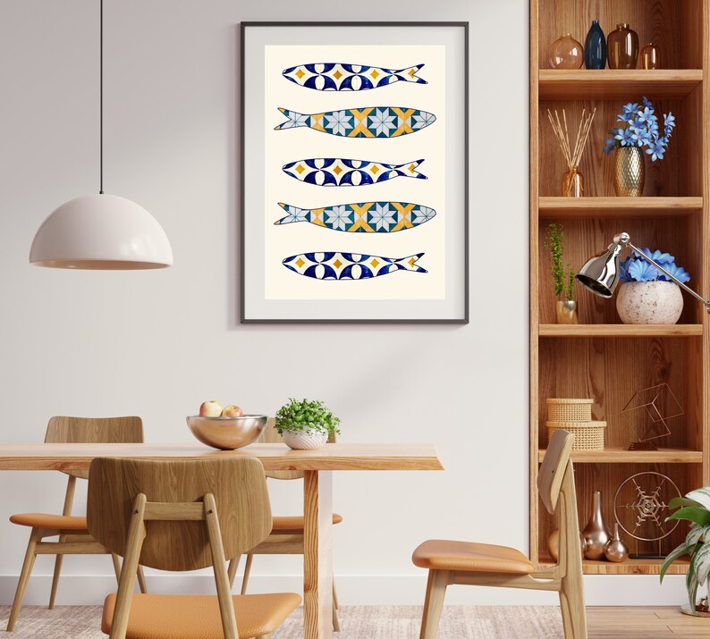 May include: A framed print of five blue and white fish with yellow accents, arranged vertically on a white background. The fish are stylized and resemble Portuguese sardines.