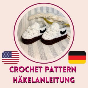May include: A pair of white and brown crochet baby sneakers with black swoosh details. The shoes have white laces and a brown sole. The image also includes the text "CROCHET PATTERN" and "HÄKELANLEITUNG".
