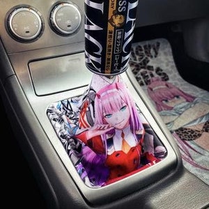 May include: A black and red anime character gear stick knob with a can of Boss Black coffee on top. The can has Japanese text that says "Boss Black" and "Suntory".