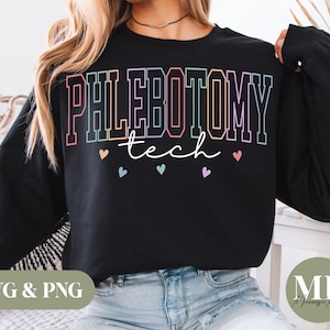 Puede incluir: Sudadera negra con las palabras "PHLEBOTOMY tech" en una fuente colorida y delineada. Pequeños corazones en colores pastel están debajo del texto. La sudadera es de estilo casual.