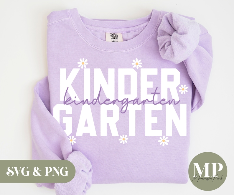 May include: A lavender sweatshirt with the text "Kinder* kindergarten* GARDEN" in white. The text is surrounded by small white daisies.