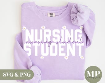 Puede incluir: Sudadera morada con el texto "Nursing Student" en letras blancas con pequeñas flores blancas alrededor del texto.