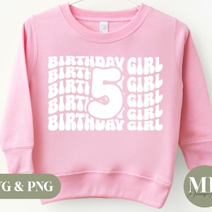 Op de afbeelding: Een lichtroze sweatshirt met de tekst "BIRTHDAY GIRL" en het nummer "5" in witte retro-letters. De sweatshirt heeft lange mouwen en een ronde hals. De tekst "SVG & PNG" staat in de linker benedenhoek.