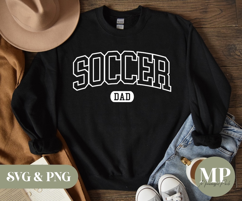Puede incluir: Sudadera negra con texto blanco que dice "SOCCER DAD" en una fuente de estilo universitario.