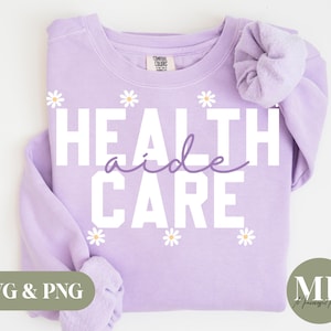 May include: Purple sweatshirt with the text "Health aide care" in white letters with a daisy pattern around the text.