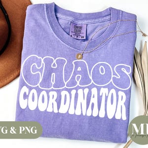 May include: Purple t-shirt with the text "Chaos Coordinator" in white retro-style lettering.
