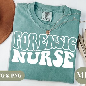 May include: A teal blue t-shirt with the text "Forensic Nurse" in white retro-style lettering. The shirt is made of a soft, comfortable material and is perfect for everyday wear.