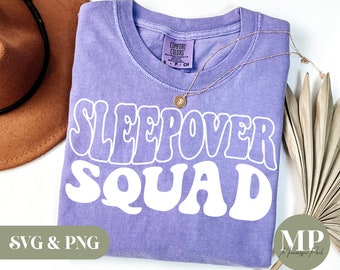 May include: Purple t-shirt with white text that says "Sleepover Squad" in a retro font. The shirt is made of a soft, comfortable material and is perfect for a sleepover party.