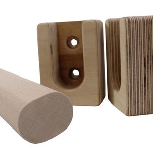 May include: A wooden pull-up bar with two wall-mounted brackets. The bar is made of natural wood and has a rounded end. The brackets are made of plywood and have a U-shaped opening to hold the bar.