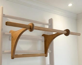 A wooden, sturdy dip bar with a removable pull-up bar that hangs from a wall bar. Perfect for a home gym, for example.