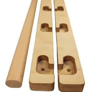 Peut inclure: Un ensemble de barres de traction en bois avec cinq positions de prise différentes. Les barres sont en bois naturel et sont conçues pour les entraînements à domicile.