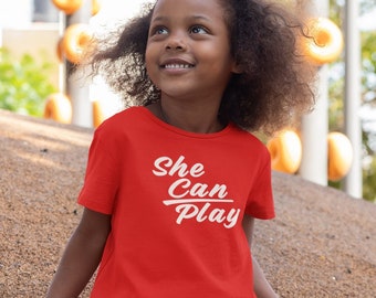 Little Kid's unisex short sleeve crew neck graphic printed T-shirt with She Can Play emblem