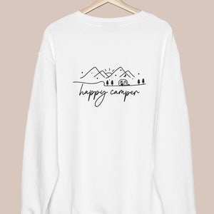 May include: White sweatshirt with a black graphic of mountains, a camper, and the text "happy camper".