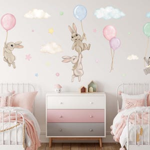 K&ouml;nnte beinhalten: Ein Set Wandaufkleber mit niedlichen Hasen, die Ballons und Wolken halten. Die Aufkleber sind perfekt f&uuml;r ein Kinderzimmer oder ein Babyzimmer. Die Hasen sind in Braun- und Graut&ouml;nen gehalten, die Ballons in Pastellfarben.