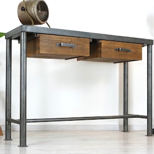Könnte beinhalten: Ein grauer Metallkonsolentisch mit zwei Schubladen aus Holz. Der Tisch hat ein schlichtes, industrielles Design und ist perfekt für einen Flur oder einen Eingangsbereich.