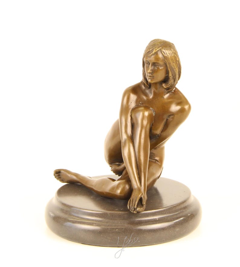 May include: A bronze sculpture of a seated figure with short hair, resting on a circular base. The figure is posed with one leg extended and the other bent, with the arms gently touching the legs. The sculpture has a smooth, polished finish.