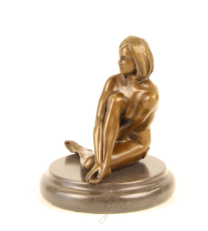 May include: A bronze sculpture of a seated figure, with short hair, gazing to the side. The figure is posed with one leg bent and the other extended, resting on a circular base. The sculpture has a polished finish and is set against a white background.