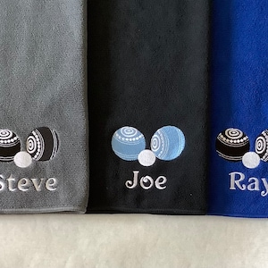 K&ouml;nnte beinhalten: Drei personalisierte Handt&uuml;cher mit den gestickten Namen "Steve", "Joe" und "Ray". Jedes Handtuch zeigt ein Paar Bowlingkugeln und eine wei&szlig;e Kugel.