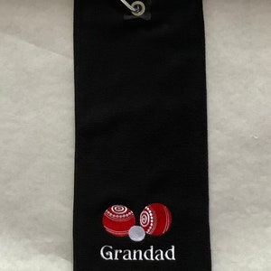 K&ouml;nnte beinhalten: Schwarzes Golftor mit einem wei&szlig;en gestickten Design aus zwei roten Bowlingkugeln und dem Wort "Grandad".