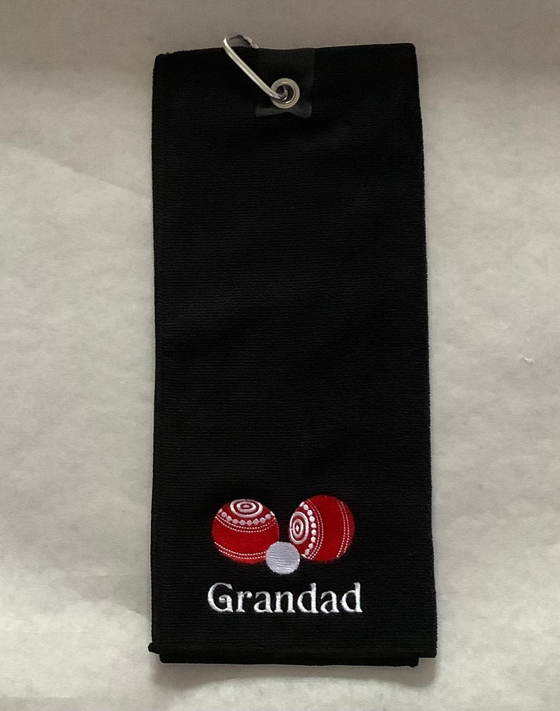 K&ouml;nnte beinhalten: Schwarzes Golftor mit einem wei&szlig;en gestickten Design aus zwei roten Bowlingkugeln und dem Wort "Grandad".