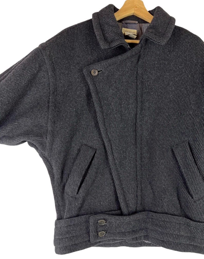 Puede incluir: Una taza de cer&aacute;mica blanca con un asa negra y el texto "But First, Coffee" en negro, con una fuente de estilo manuscrito. La taza est&aacute; sobre una superficie blanca.